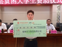 董事長(zhǎng)賀金龍與被資助的貧困大學(xué)生合影